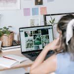 Woman sitting at table and searching images on laptop